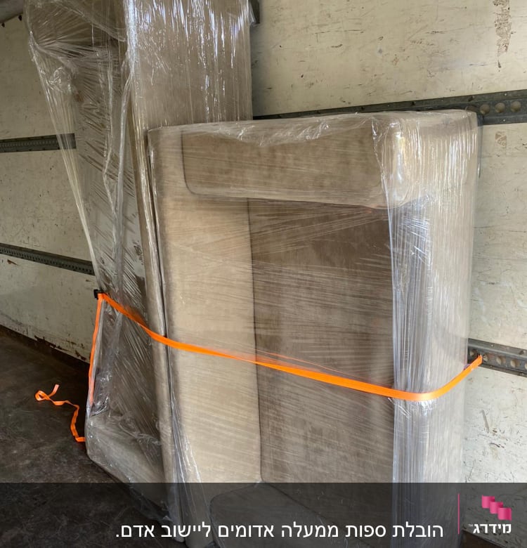 רהיטים עטופים בניילון עם רצועה כתומה במשאית